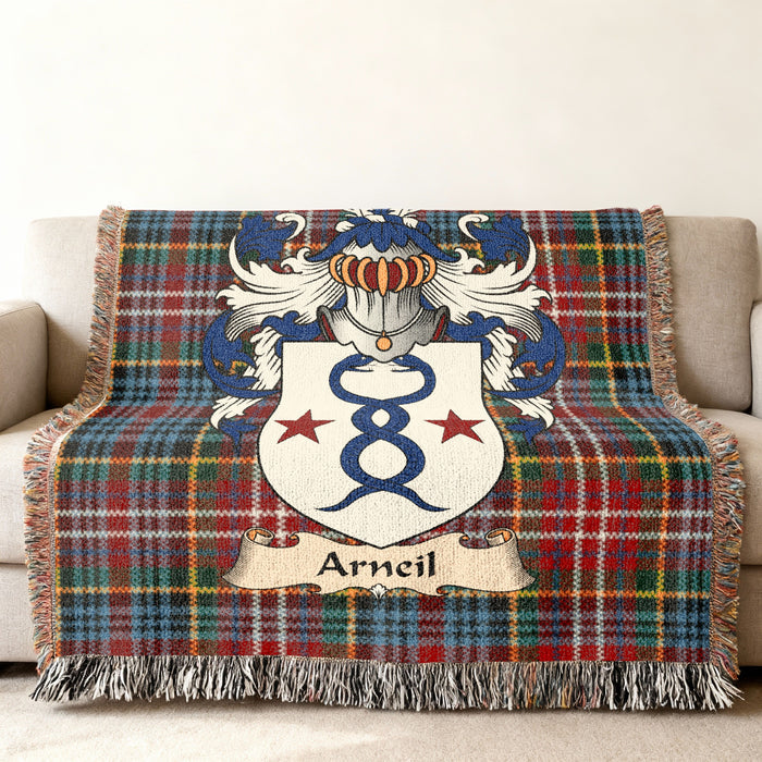 Arneil Scottish family shield woven blanket with Caledonia tartan background on a sofa