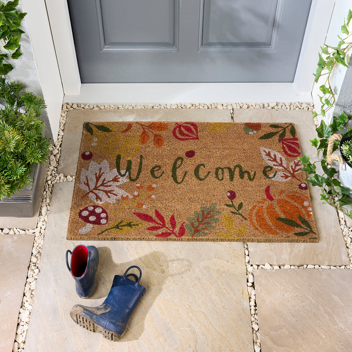 Discover the Autumnal Welcome Coir Doormat- a coir doormat featuring leaves, berries, pumpkins and mushrooms with a graphic font.
