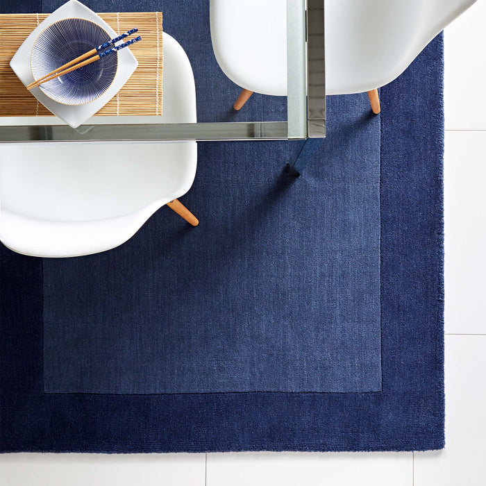 Borders Navy Blue 100% wool rug with a two-tone border design, styled in a dining room.
