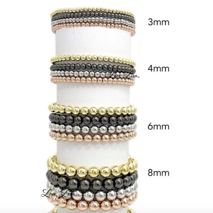 Classic beaded stretch bracelets by Love Lisa in various colors with intricate bead designs showcased on a white background.