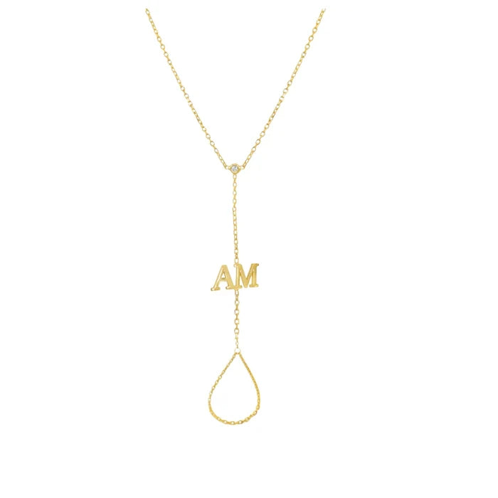 A delicate gold Y-necklace featuring a small 'AM' initial pendant and a teardrop-shaped dangling loop, shown on a plain white background.