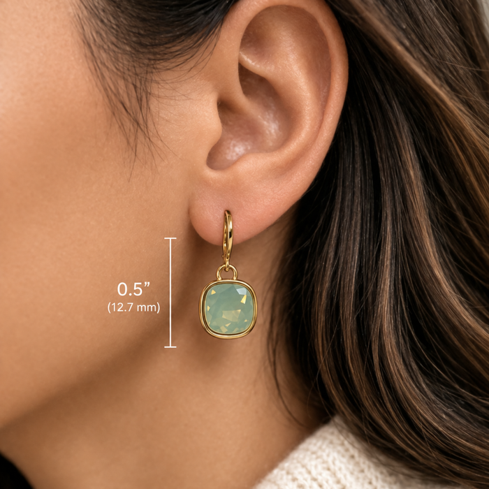 Cathie Nilson framed drop earrings with geometric design and silver finish, hanging from a delicate hook.