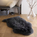 Single Sheepskin Black Rug made up of long-haired wool, styled on wooden flooring.