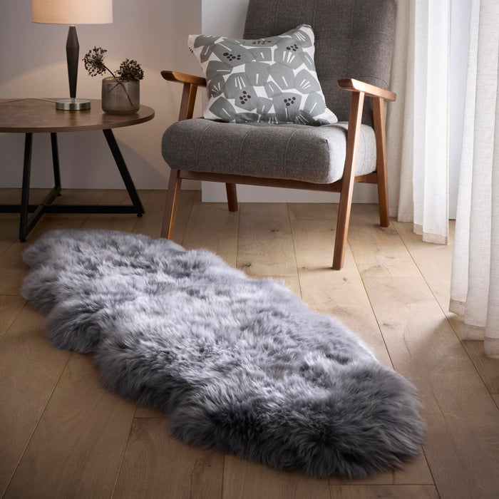 Double Sheepskin Grey Rug made from long-haired wool, styled on wooden flooring.