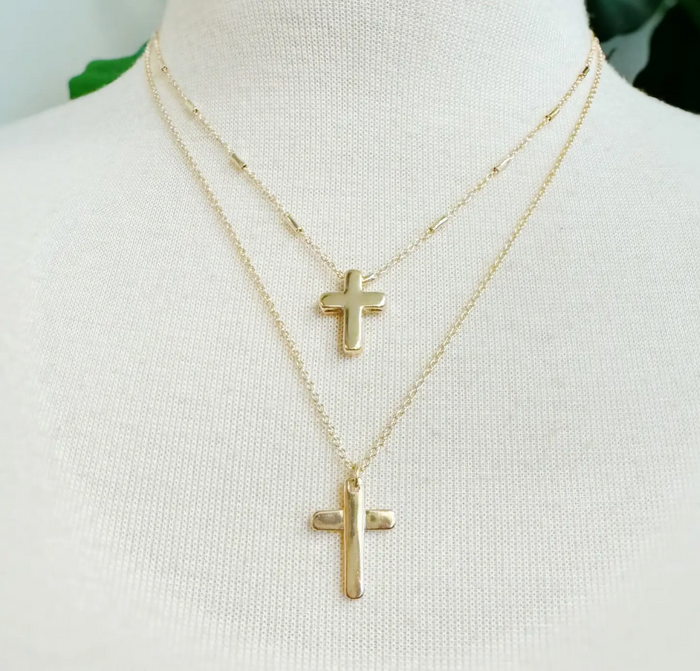 Gold cross necklace from Ellison + Young featuring a polished cross pendant on a delicate chain.