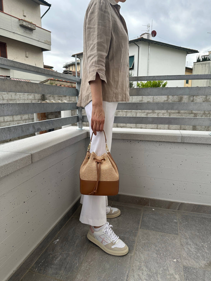 Private label MISS Bucket classic raffia crossbody bag with woven straw texture and adjustable shoulder strap.