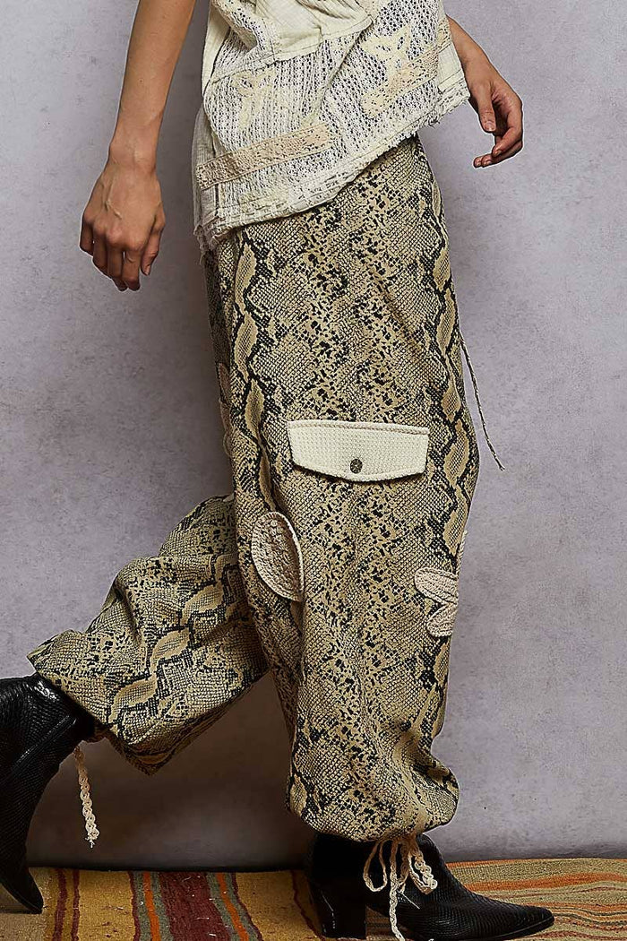Pol Clothing pleat detail floral patchwork cargo pants with relaxed fit and multiple pockets, showcasing vibrant floral patterns.