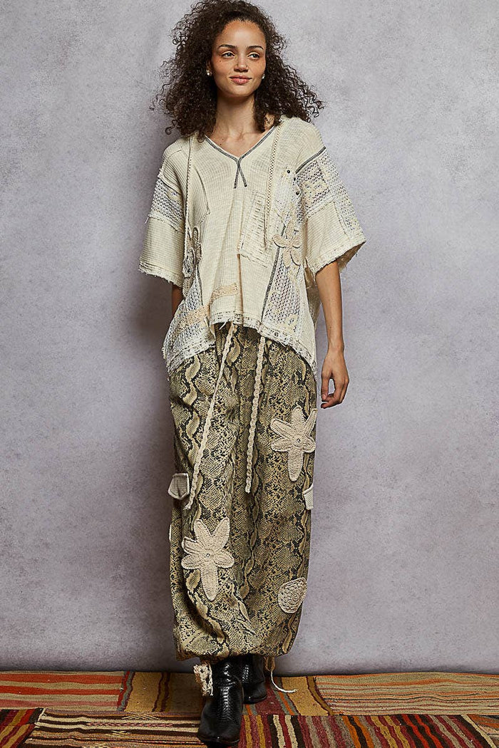 Pol Clothing pleat detail floral patchwork cargo pants with multiple pockets and relaxed fit, showcasing floral and pleat design elements.