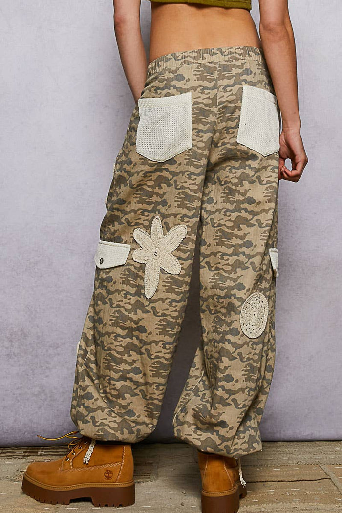 Pol Clothing pleat detail floral patchwork cargo pants showing colorful floral patches, pleats, and relaxed cargo style.