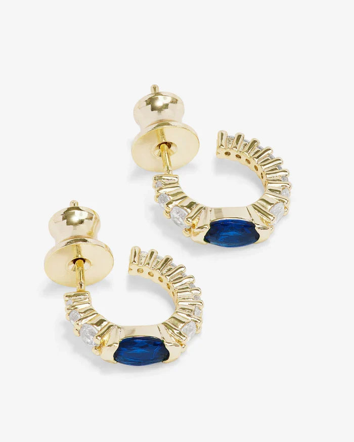 Silver hoop earrings called The Maven Huggies by Melinda Maria, close-up view showing their sleek, minimalist design.